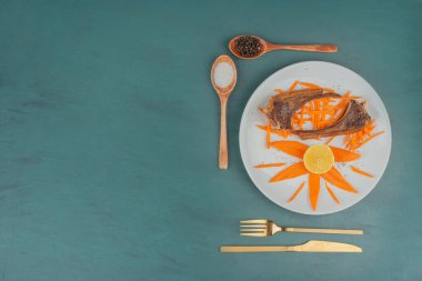 Beyaz tabakta ızgara kuzu pirzolası, havuç dilimleri ve çatal bıçak takımı. Yüksek kalite fotoğraf