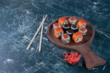 Tahta üzerinde yemek çubukları olan üç çeşit suşi. Yüksek kalite fotoğraf