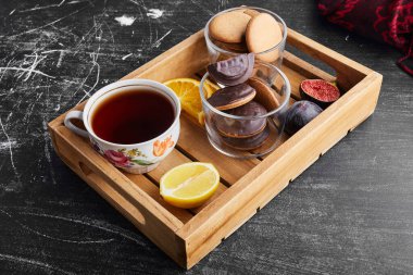 Tahta tepside bir fincan çayla çikolatalı kurabiye. Yüksek kalite fotoğraf