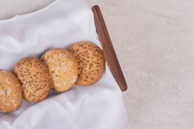 Beyaz yüzeyinde susam tohumları olan bir sepet kurabiye. Yüksek kalite fotoğraf
