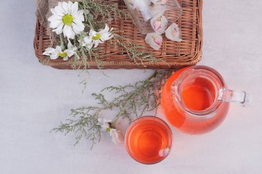 Beyaz arka planda çiçekler olan bir bardak kırmızı limonata. Yüksek kalite fotoğraf