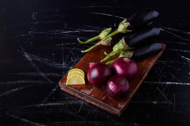 Siyah arka planda kırmızı soğanlı mor patlıcan. Yüksek kalite fotoğraf