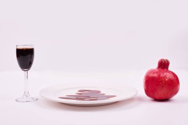 Beyaz arka planda bir bardak sos, beyaz tabak ve nar. Yüksek kalite fotoğraf