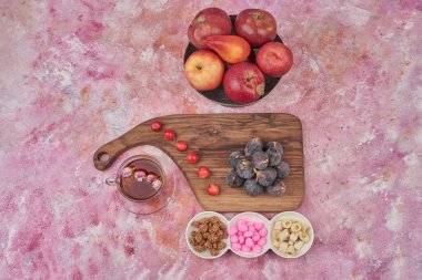 Pembe arka planda elmalı ve şekerli mor incirler. Yüksek kalite fotoğraf