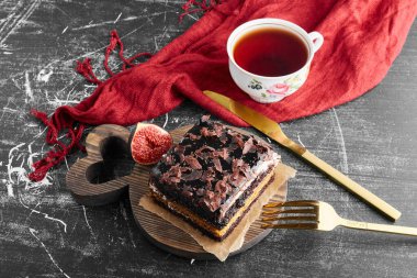 İncirli bir dilim çikolatalı kek ve bir fincan çay. Yüksek kalite fotoğraf