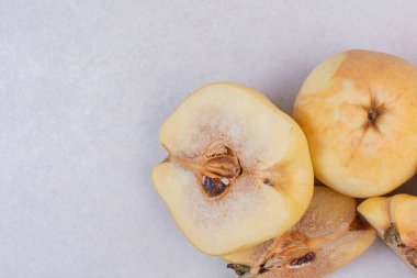 Yarısı kesilmiş ayva ve bütün ayva beyaz masada. Yüksek kalite fotoğraf