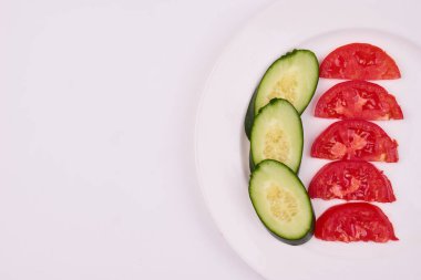 Beyaz tabakta dilimlenmiş salatalık ve domates. Yüksek kalite fotoğraf