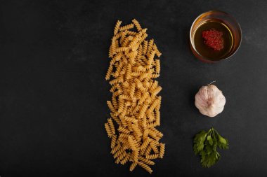 Çiğ makarna ve siyah arka planda malzemeler. Yüksek kalite fotoğraf