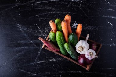 Ahşap bir tepside siyah arka planda sebze kompozisyonu. Yüksek kalite fotoğraf