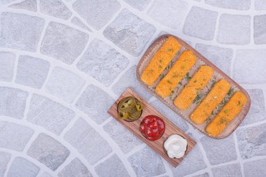 Tavuk nugget çubukları ahşap bir tepside soslu. Yüksek kalite fotoğraf