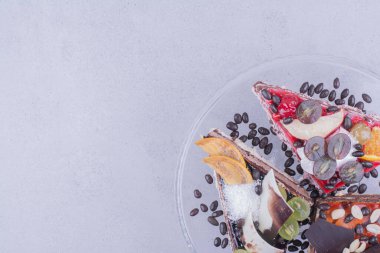 Çikolata, fındık ve meyveli cam tabakta üçgen şeklinde pasta dilimleri. Yüksek kalite fotoğraf