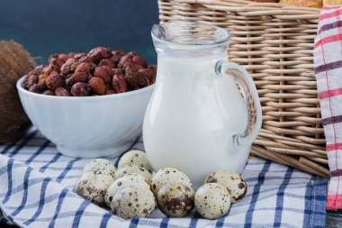 Bir kavanoz süt, kurutulmuş hurma ve masa örtüsünün üstünde bıldırcın yumurtası. Yüksek kalite fotoğraf