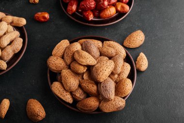 Siyah arka planda, tabakta badem kabukları. Yüksek kalite fotoğraf