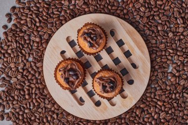 Gri arkaplanda kahve çekirdekleri ve kekler. en üstteki görünüm.