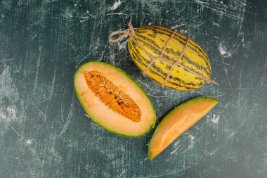 Mermer yüzeyde tam ve dilimlenmiş kavunlar. Yüksek kalite fotoğraf
