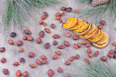 Kurumuş portakal dilimleri ve mermer arka planda kalçalar. Yüksek kalite fotoğraf