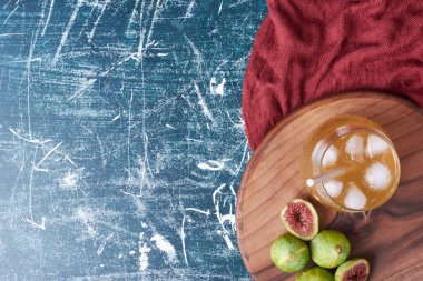 Mavi arka planda bir bardak içkili yeşil incir. Yüksek kalite fotoğraf