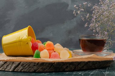 Sıcak, aromalı çaydanlık ve jöle şekerli ahşap tahtada. Yüksek kalite fotoğraf