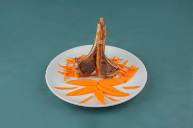 Beyaz tabakta kuzu pirzolası ve havuç dilimleri. Yüksek kalite fotoğraf