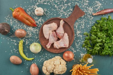 Etrafta makarna ve sebzelerle ahşap bir tahtanın üzerinde tavuk eti. Yüksek kalite fotoğraf