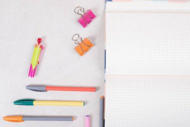 Beyaz arka planda açık not defteri olan beş renkli kalem. Yüksek kalite fotoğraf