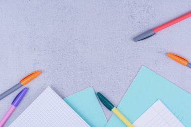 Boş kağıtlar ve gri arka planda çok renkli kalemler. Yüksek kalite fotoğraf