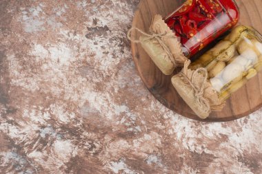 Ahşap tabakta cam bir kavanozda kırmızı biber ve mantar turşusu. Yüksek kalite fotoğraf