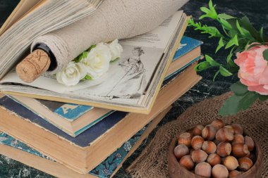 Kitaplı fındıklar ve mermer arka planda bir vazo çiçek. Yüksek kalite fotoğraf