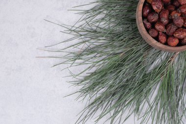 Bir kase kurutulmuş kızılcık ve mermer masanın üzerinde çam dalı. Yüksek kalite fotoğraf