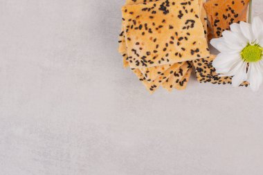 Beyaz arka planda çiçekli siyah susam tohumlu çıtır ekmek parçaları. Yüksek kalite fotoğraf