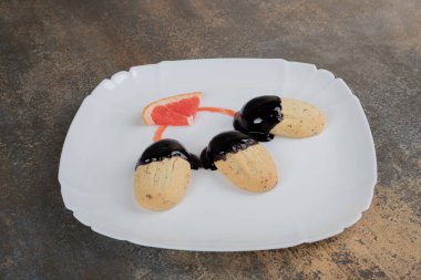 Mermer masada çikolata sosuyla süslenmiş bir tabak kurabiye. Yüksek kalite fotoğraf