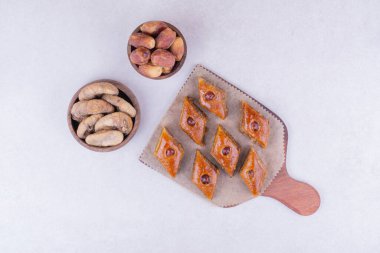 Kuru incir ve hurma dolu ahşap bir tepside beyaz pakhlava. Yüksek kalite fotoğraf