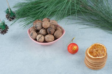 Ceviz dolu pembe bir tabak ve mermer arka planda tatlı kurabiyeler. Yüksek kalite fotoğraf