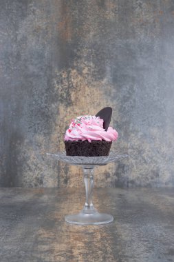 Mermer zemin üzerinde cam tabakta pembe kremalı kek. Yüksek kalite fotoğraf