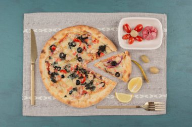 Lezzetli sıcak pizza ve mavi arka planda bir tabak sebze turşusu. Yüksek kalite fotoğraf