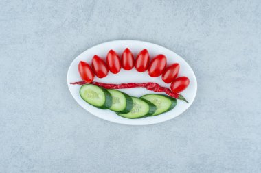 Beyaz tabak salatalık, domates vişneli ve biberli. Yüksek kalite fotoğraf