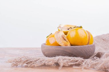 Çuval bezi üzerinde ahşap bir fincanda sarı hurma erikleri. Yüksek kalite fotoğraf