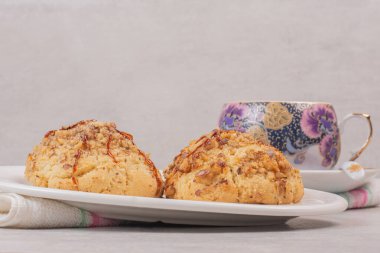 Beyaz masada bir tabak kurabiye ve bir fincan çay. Yüksek kalite fotoğraf