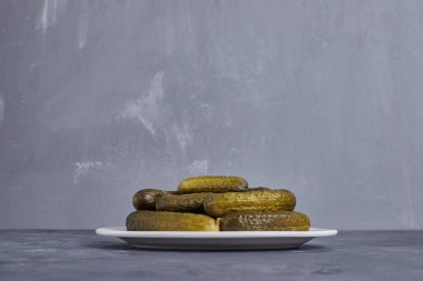 Mavi arka planda beyaz tabakta salatalık turşusu. Yüksek kalite fotoğraf