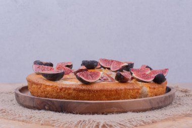 İncirli ve ahşap tabakta şerbetli vanilyalı turta. Yüksek kalite fotoğraf