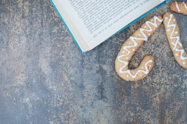 Mermer zemin üzerine kitabı olan üç tatlı Noel kurabiyesi