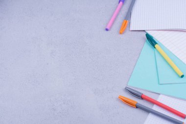 Boş kağıtlar ve gri arka planda renkli kalemler. Yüksek kalite fotoğraf