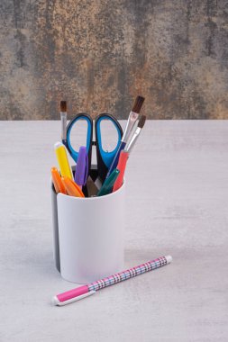 Kalem tutacağında makas, fırça ve kalemler var. Yüksek kalite fotoğraf