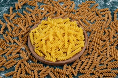 Mavi arka planda sarı ve kahverengi fusilli makarna. Yüksek kalite fotoğraf