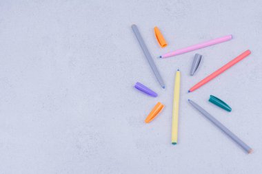 Gri arkaplanda beş tane çok renkli jel kalem var. Yüksek kalite fotoğraf