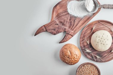 Tahta bir tabakta, yanında da pişirilmiş el yapımı yuvarlak ekmek hamuru. Yüksek kalite fotoğraf