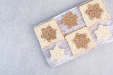 Tahta tabakta yıldız ve kare şeklinde siyah ve beyaz ekmek dilimleri. Yüksek kalite fotoğraf