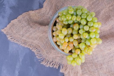 Mavi arka planda kırsal bir kupada yeşil üzümler. Yüksek kalite fotoğraf