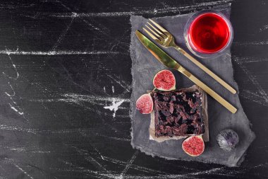 Siyah arka planda çikolatalı cheesecake dilimi ve bir bardak şarap. Yüksek kalite fotoğraf