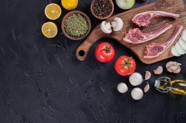 Tahtada üç çiğ et pirzolası, limon, sarımsak, yağ ve baharatla. Yüksek kalite fotoğraf